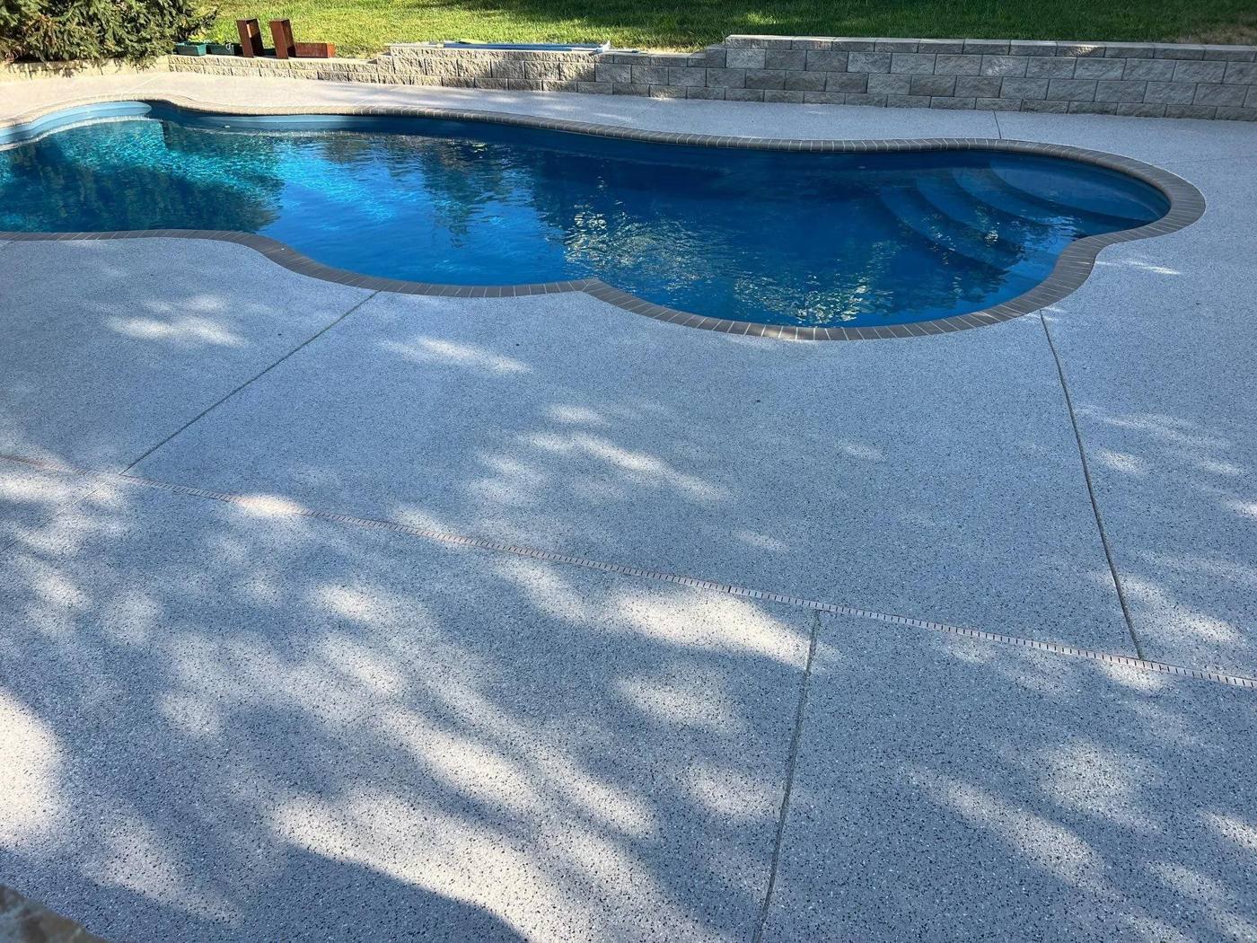 Renewed textured coating on a residential pool deck around a freeform pool